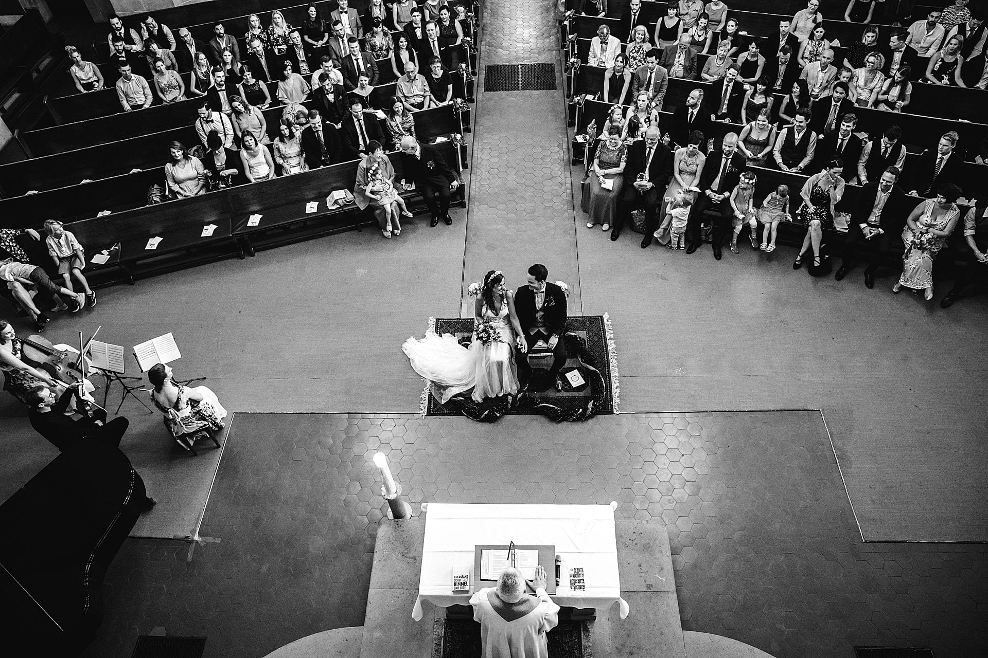 Blick von oben auf das Hochzeitspaar während der kirchlichen Trauung.
